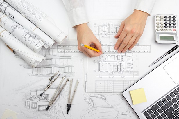 Architect working on blueprint. Architects workplace - architectural project, blueprints, ruler, calculator, laptop and divider compass. Construction concept. Engineering tools.